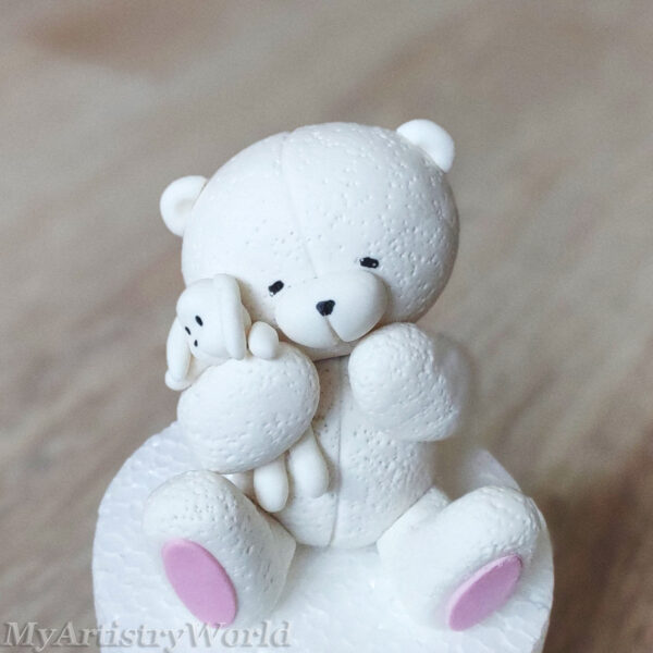 Bear holding a toy bunny cake topper